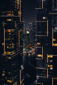 Night view of illuminated skyscrapers in a bustling city, showcasing the importance of Airflow Sensors in optimizing HVAC systems for high-rise buildings.